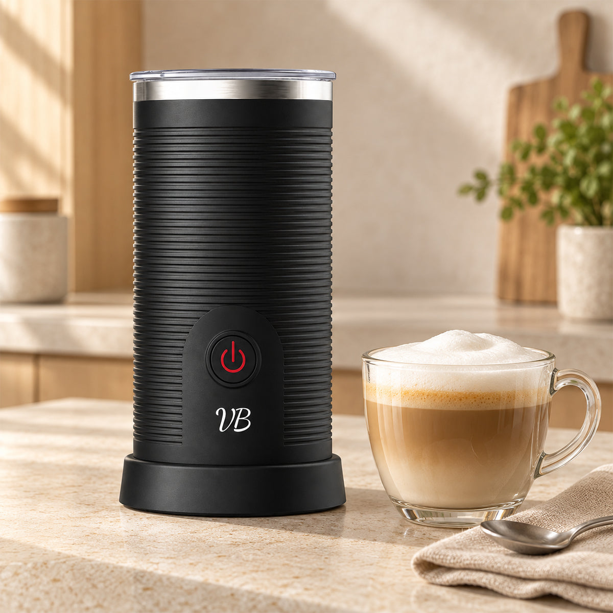 Mousseur à lait Velvet Bliss dans la cuisine à côté d'un verre de latte macchiato avec mousse de lait